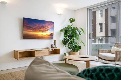 a living room with a couch and a table at Beach Front Urban 2 Bedrooms in Sydney