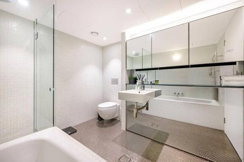a bathroom with a sink and a tub and a toilet at Beach Front Urban 2 Bedrooms in Sydney