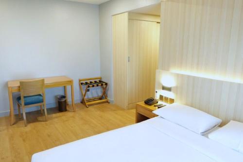 a hotel room with two beds and a table and a desk at The Linden Suites in Manila