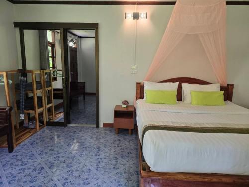 a bedroom with a bed with a canopy at Malulee KhaoSok Resort in Khao Sok