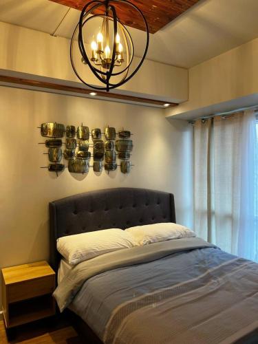 a bedroom with a bed with a chandelier above it at Velasco Place in Manila