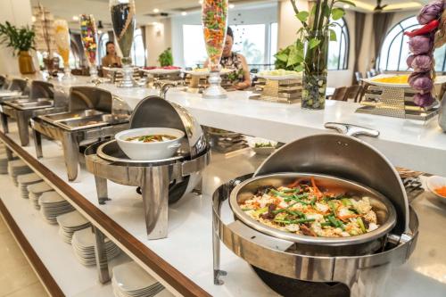 a buffet line of dishes in a restaurant at Maris Beach Hotel Phu Quoc in Phu Quoc