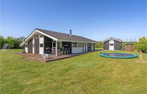 a house with a backyard with a trampoline at Holiday Home Ejstrupholm With Hot Tub Xiv in Ejstrup