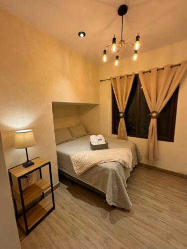 a bedroom with a bed and a table with a lamp at 5 Suites Boutique cerca Antigua Guatemala in San Pedro Las Huertas