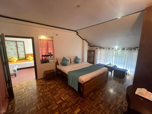 a bedroom with a bed and a room with a window at Bahar Retreat And Spa , Gangtok in Gangtok
