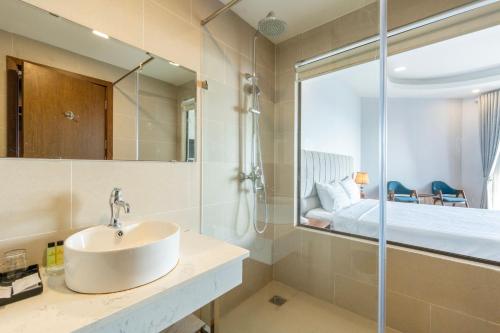 a bathroom with a sink and a shower and a bed at Maris Beach Hotel Phu Quoc in Phu Quoc