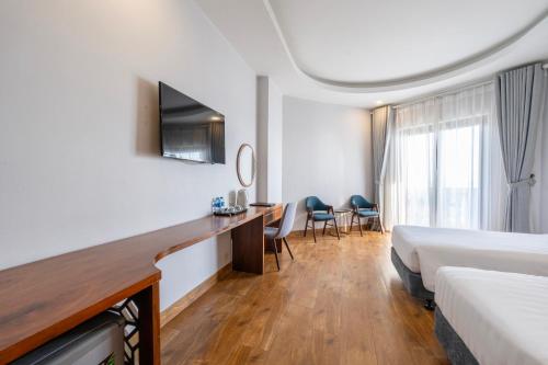 a hotel room with a bed and a desk at Maris Beach Hotel Phu Quoc in Phu Quoc