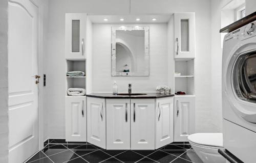a bathroom with a sink and a washing machine at Lovely Home In Ørsted With Wifi in Ørsted