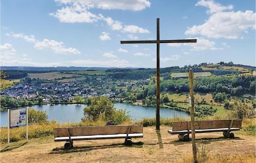 a cross on top of a hill with two benches at Holiday Home Gunderath With Fireplace I in Gunderath