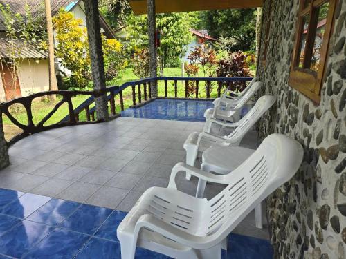 two white plastic chairs sitting on a porch at Malulee KhaoSok Resort in Khao Sok