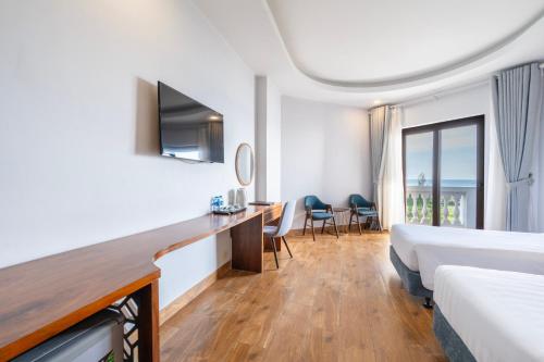 a hotel room with a bed and a desk at Maris Beach Hotel Phu Quoc in Phu Quoc