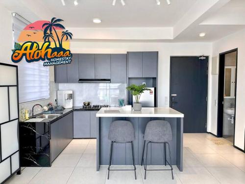 a kitchen with a island with two bar stools at Urban Suite Modern Lifestyle Seaview Georgetown in Jelutong