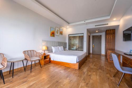 a bedroom with a bed and a table and chairs at Maris Beach Hotel Phu Quoc in Phu Quoc