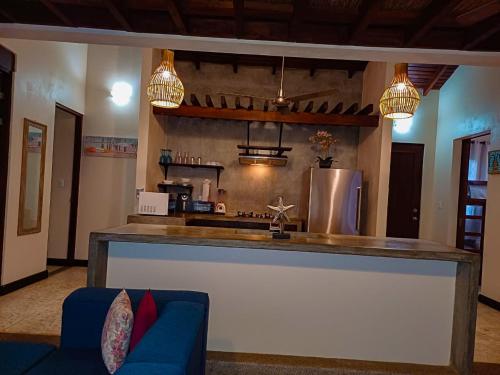 a kitchen with a counter and a blue couch at Beach Walk Costa Rica in Playa Avellana