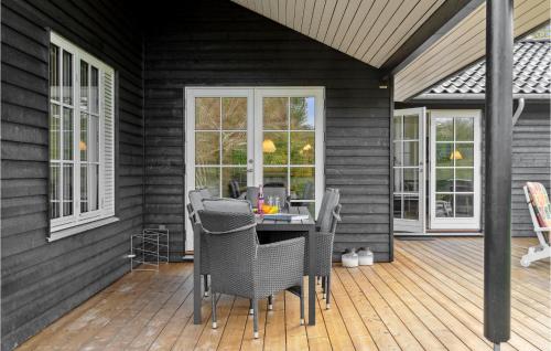 a screened in porch with a table and chairs at Awesome Home In Græsted With Wifi in Græsted