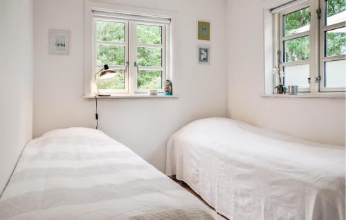 two beds in a white room with windows at Holiday Home Køgehusvej in Frederiksværk