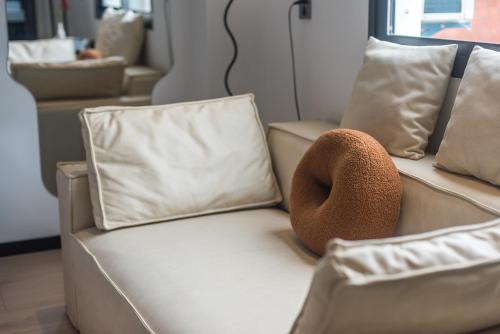 a brown hat sitting on a couch with pillows at Quanzhou West Street Kaiyuan Temple Bandiao Inn in Quanzhou