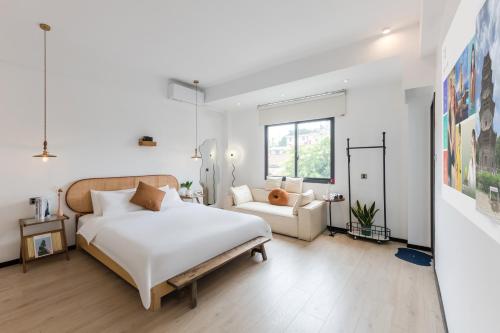 a bedroom with a large white bed and a couch at Quanzhou West Street Kaiyuan Temple Bandiao Inn in Quanzhou