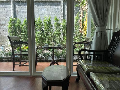 a living room with a couch and a table and window at Baan Debtida in Bangkok