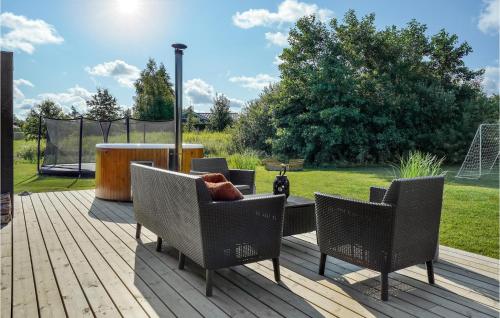 a deck with two chairs and a table with a soccer ball at 3 Bedroom Amazing Home In Hørve in Hørve