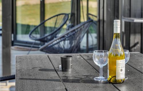 a bottle of wine and a wine glass on a table at 3 Bedroom Amazing Home In Hørve in Hørve