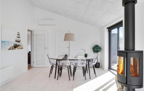 a dining room with a table and chairs and a fireplace at 3 Bedroom Amazing Home In Hørve in Hørve