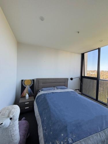 a bedroom with a large bed and a balcony at Cozy 1 Bedroom Apt Parkside Pool Gym Parking close CBD in Melbourne