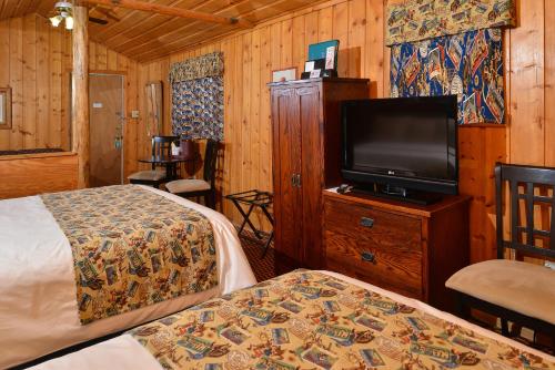 A bed or beds in a room at Buffalo Bill Cabin Village