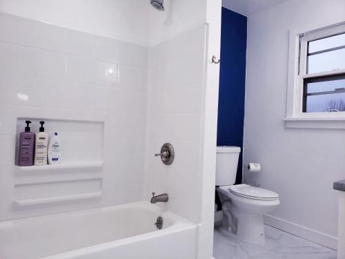 a bathroom with a white tub and a toilet at Downtown on BSU Campus 3 Beds Fully Remodeled in Boise