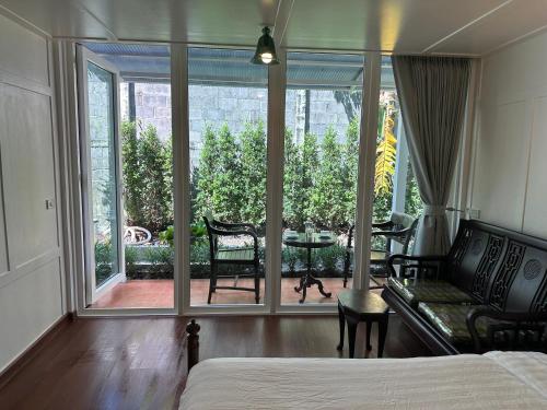a bedroom with a bed and a large window with a patio at Baan Debtida in Bangkok