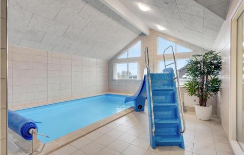 a swimming pool with a blue slide in a room at Awesome Home In Sydals With Sauna in Sarup