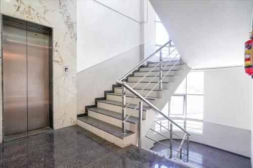 a staircase in a building with a metal door at FabHotel Prime Majhali in Nashik