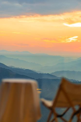 a view of a sunset with a table and mountains at Rice View Lodge in Longsheng