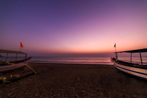 two boats sitting on the beach at sunset at Om Shanti Beach Stay Patnem in Patnem