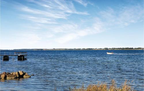 a boat on a large body of water with a dock at Holiday Home Stubbekobing With Fireplace I in Ore