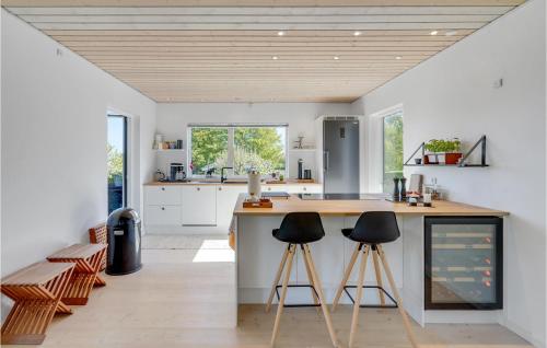 a kitchen with two bar stools and a counter at Holiday Home Stubbekobing With Fireplace I in Ore