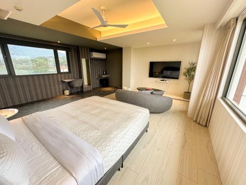 Fair Tale Motel - Sea في مدينة هوالين: غرفة نوم بها سرير وأريكة وجهاز تلفزيون