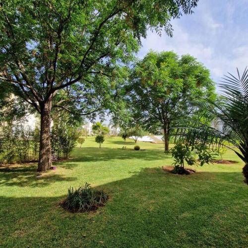 a park with trees and green grass and a field at Villa Joudia Royal Golf Fes in Fès