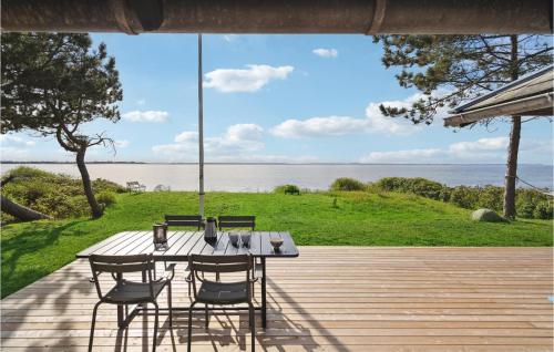 a table and chairs on a deck with a view of the water at Awesome Home In Martofte With Wifi in Martofte