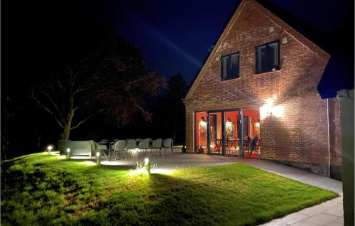 a house with chairs and lights in the yard at night at Gubbegård in Neksø