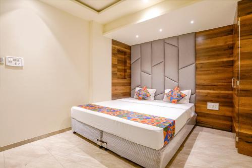 a bedroom with a bed and a wooden wall at FabHotel Prime Majhali in Nashik
