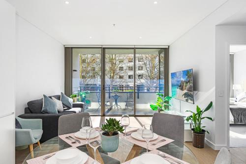 a living room with a couch and a table and chairs at ChinatownICCHaymarket Adorable 2Br Apt at CBD in Sydney