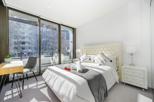a bedroom with a bed and a desk and a window at ChinatownICCHaymarket Adorable 2Br Apt at CBD in Sydney