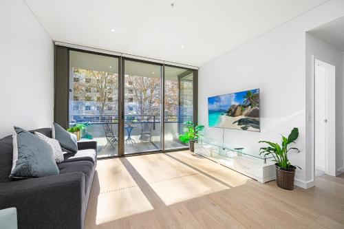 a living room with a couch and large windows at ChinatownICCHaymarket Adorable 2Br Apt at CBD in Sydney