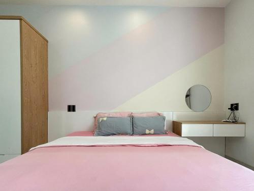 a bedroom with a pink bed in a room at Sea House Hotels and Apartments in Vung Tau