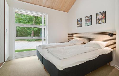 Una cama o camas en una habitación de Rubinsøen Skovhuse