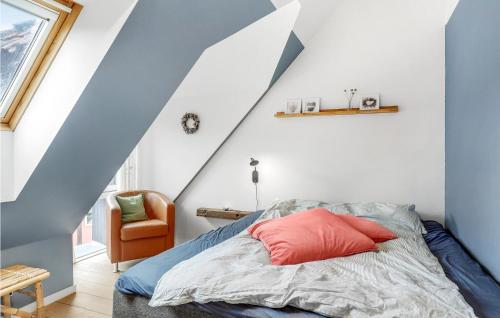 a bedroom with a bed and a blue and white wall at 2 Bedroom Cozy Apartment In Svaneke in Svaneke