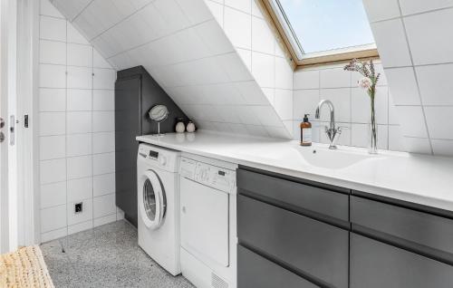 a laundry room with a sink and a washing machine at 2 Bedroom Cozy Apartment In Svaneke in Svaneke