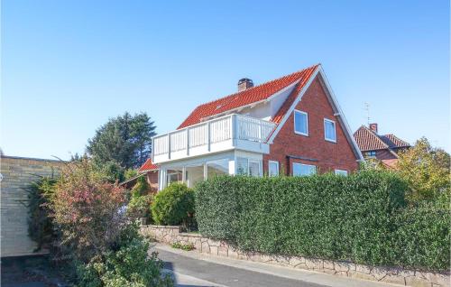 a large red brick house with a white balcony at Nice Home In Allinge With Kitchen in Allinge