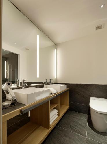 a bathroom with a sink and a toilet and a mirror at 22 PIECES in Kyoto